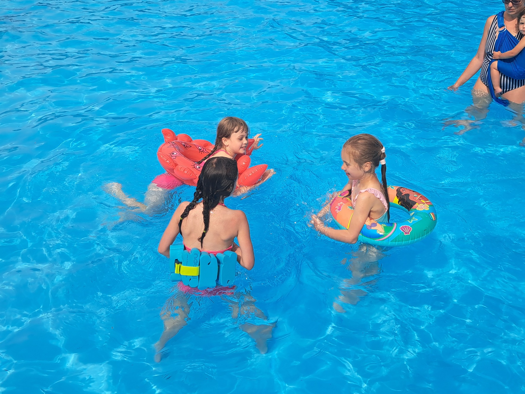 Děti se koupají v bazénu na letním táboře pro nejmenší.