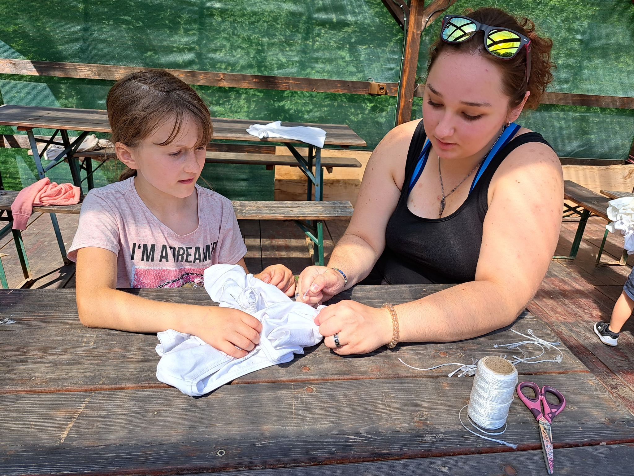 Děti kreslí na letním táboře pro nejmenší venku v přírodě.