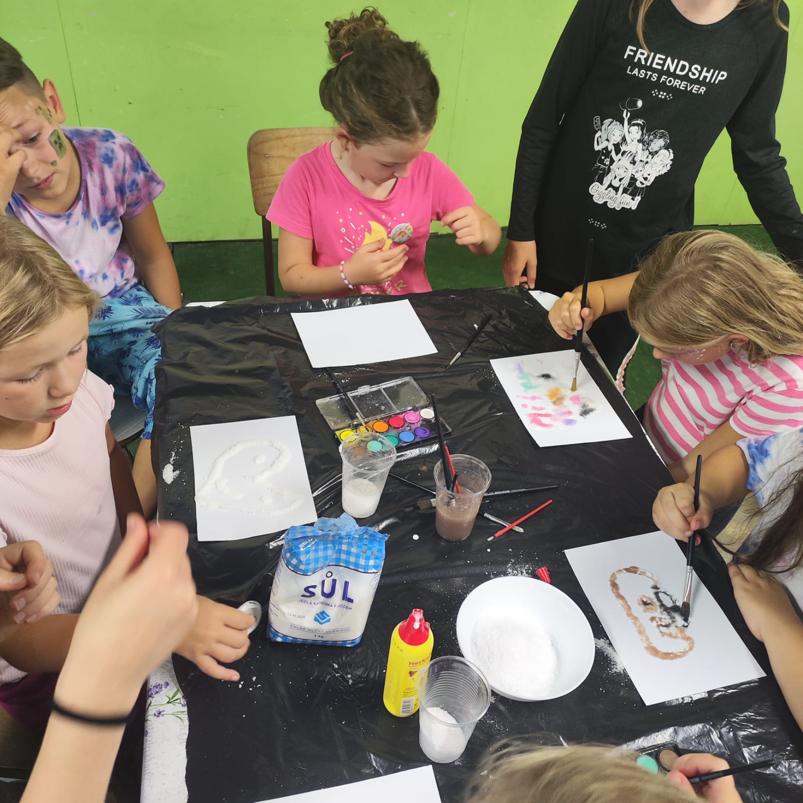Děti kreslí a malují na letním výtvarném táboře.
