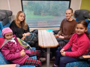 Děti na podzimním táboře Amaritta jedou vlakem na výlet.