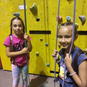 Děti lezou na lezecké stěně na letním dětském táboře Amaritta.