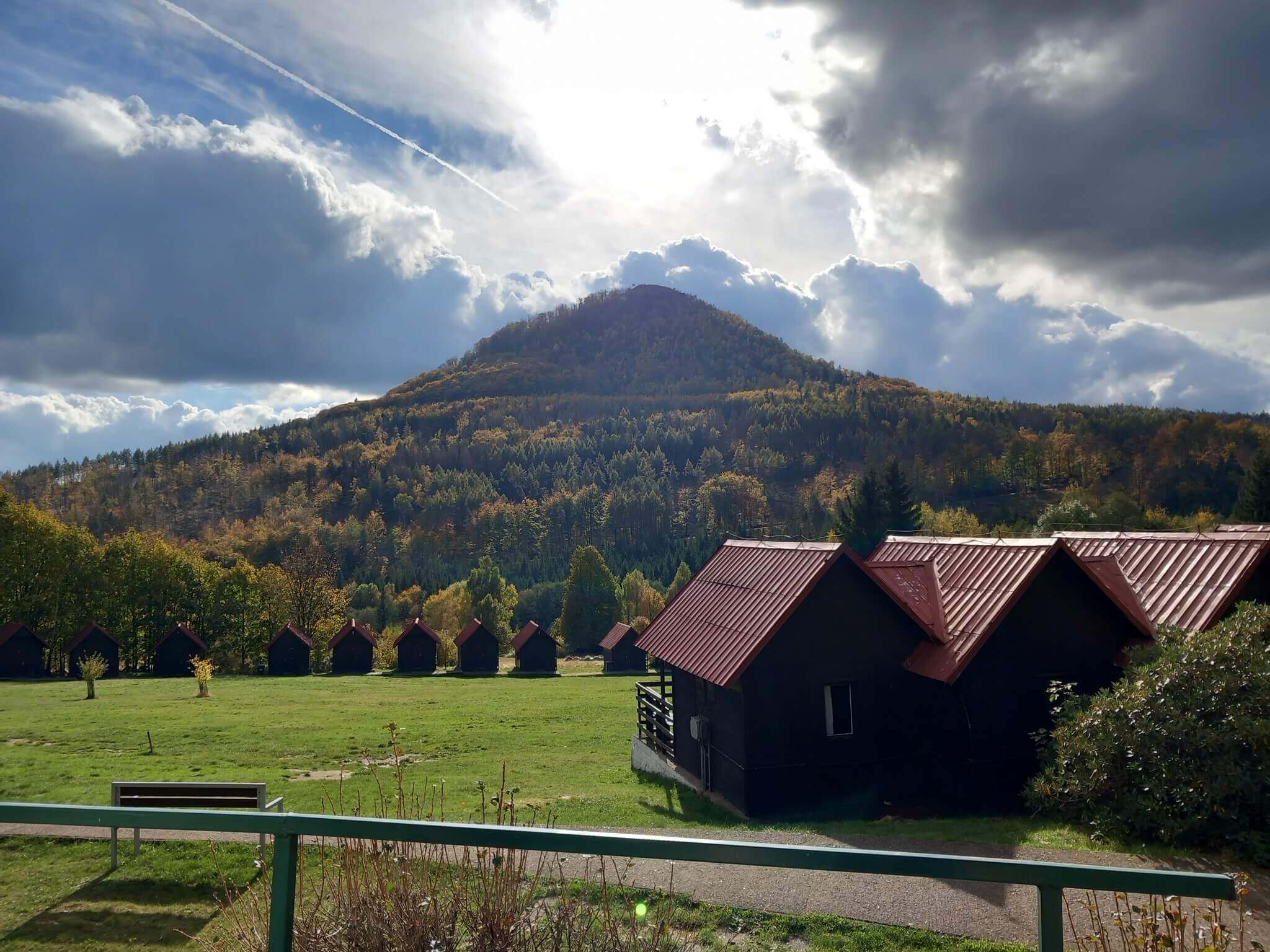 Rekreační středisko a nejvyšší hora Lužických hor Klíč v záři slunce prosvítajícího mezi mraky na podzimním dětském táboře.